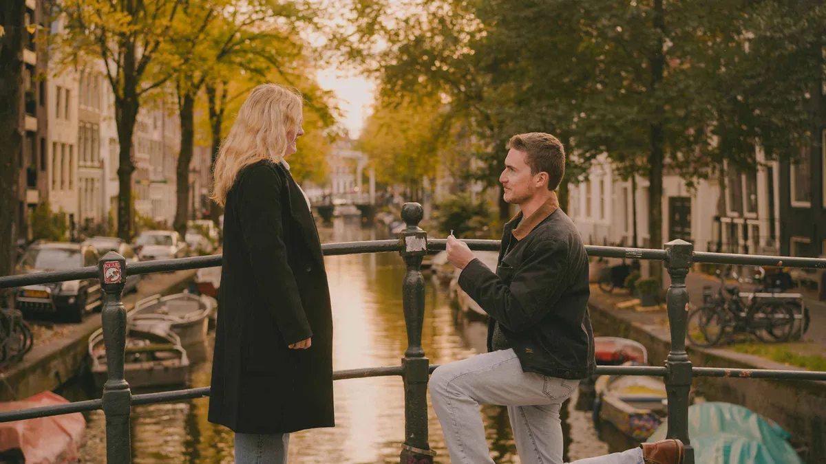 Surprise proposal photographed discreetly on a canal bridge during an Amsterdam photoshoot, Amsterdam